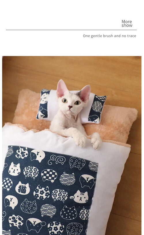 Cat tucked into a navy pet sleeping bag with its own pillow